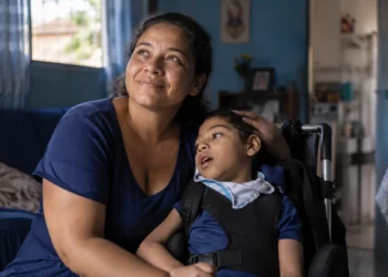 Mãe brasileira cuidando de filho com deficiência em cadeira de rodas, representando o Auxílio Mãe Atípica, com benefício previsto de R$ 600 e adicional de R$ 150 por dependente.
