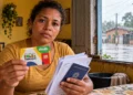 Mulher segura cartão do Bolsa Família durante situação de emergência