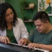 Musicoterapeuta acompanha paciente durante atividade terapêutica com teclado