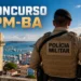 Policial militar da Bahia de costas com uniforme da Polícia Militar diante de paisagem de Salvador.
