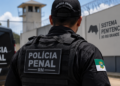 Policial penal do Rio Grande do Norte em frente a unidade prisional representando concurso público da Polícia Penal-RN.