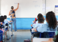 Professora em sala de aula da rede pública com estudantes, representando o concurso SEDF 2026.