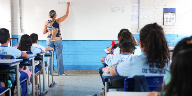 Professora em sala de aula da rede pública com estudantes, representando o concurso SEDF 2026.