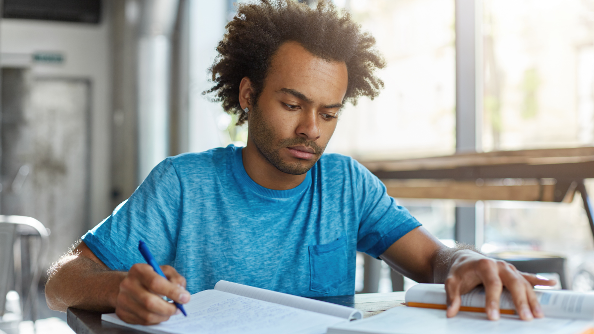 Pessoa estudando para concurso público com material de preparação.