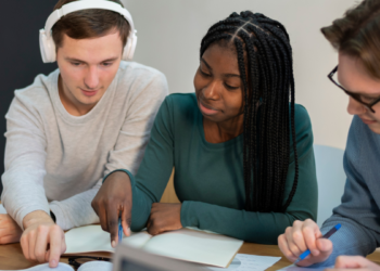Pessoas estudando e se preparando para concursos públicos com materiais de estudo sobre a mesa.