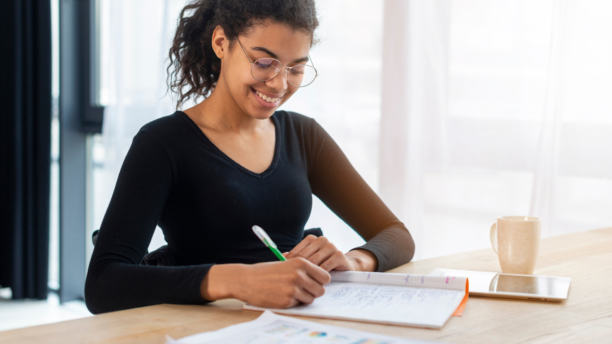 Candidata estuda para concurso público com caderno e materiais de preparação.