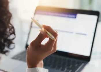 Pessoa estudando para concursos públicos com notebook e material de apoio, representando oportunidades abertas em São Paulo e Rio de Janeiro.