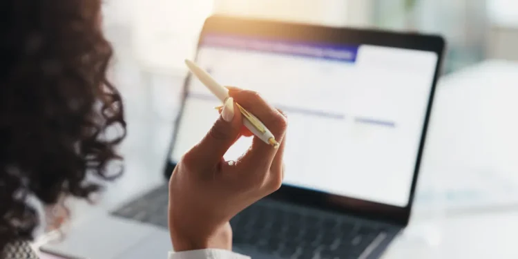 Pessoa estudando para concursos públicos com notebook e material de apoio, representando oportunidades abertas em São Paulo e Rio de Janeiro.