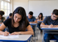 Candidatos realizam prova de concurso público em sala de aula representando oportunidades com inscrições prorrogadas.