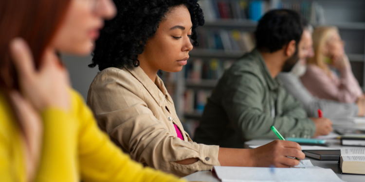 Candidatos estudando para concursos públicos em ambiente de preparação com livros e materiais de apoio.