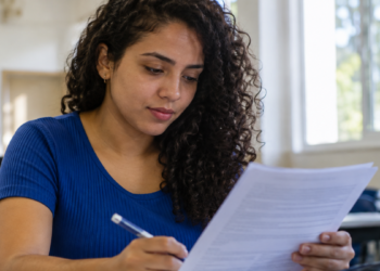 Jovem preenche formulário de concurso público durante preparação para processos seletivos com inscrições abertas.