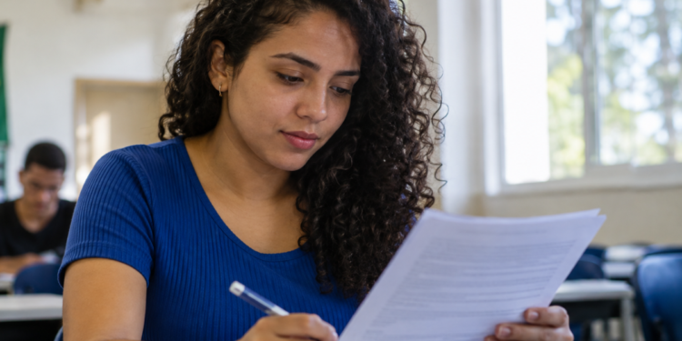 Jovem preenche formulário de concurso público durante preparação para processos seletivos com inscrições abertas.