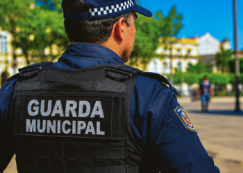 Guarda municipal fardado representa concursos com vagas em Piumhi, Itatinga e Paulínia.