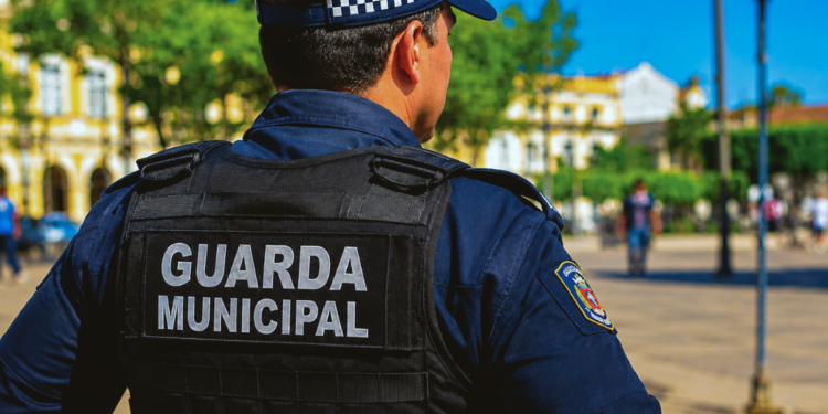 Guarda municipal fardado representa concursos com vagas em Piumhi, Itatinga e Paulínia.