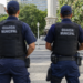 Dois guardas municipais de costas em praça pública representam concursos com vagas abertas em setembro.