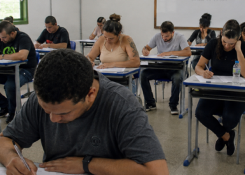 Candidatos realizam prova de concurso público em sala de aula durante processo seletivo municipal.