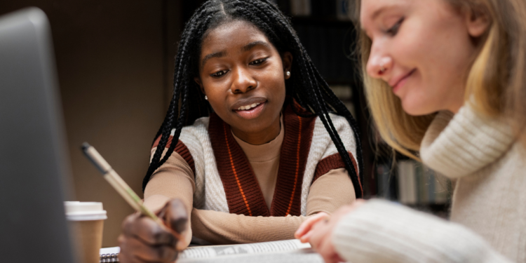 Pessoas estudando com livros e notebook para preparação para concursos públicos.