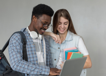 Estudantes consultam informações em notebook representando concursos públicos com inscrições abertas.