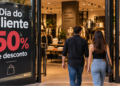 Duas pessoas entrando em loja de roupas com promoção de 50% de desconto no Dia do Cliente 2026.