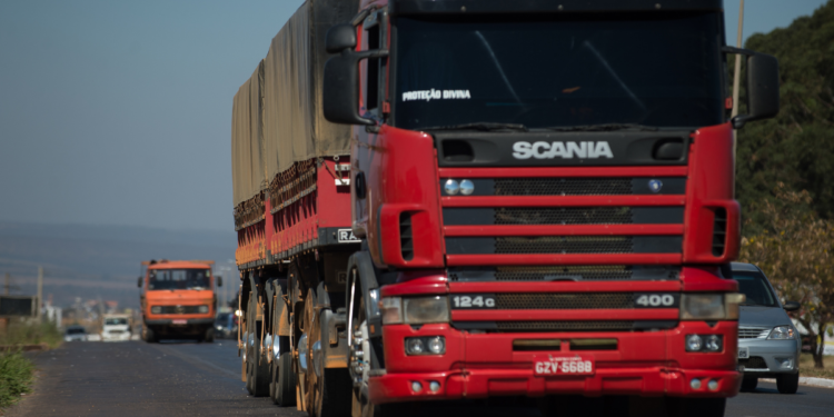 Caminhão de carga circula por rodovia representando o trabalho dos caminhoneiros.