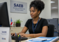 Jovem universitária trabalha em computador durante estágio em órgão público da Bahia.