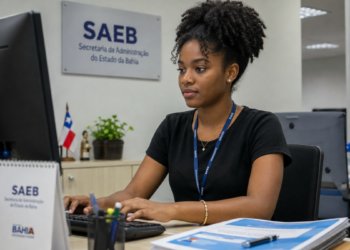 Jovem universitária trabalha em computador durante estágio em órgão público da Bahia.