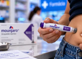 Pessoa aplica caneta de Mounjaro no abdômen, com embalagem ao fundo, destacando a grafia correta do medicamento
