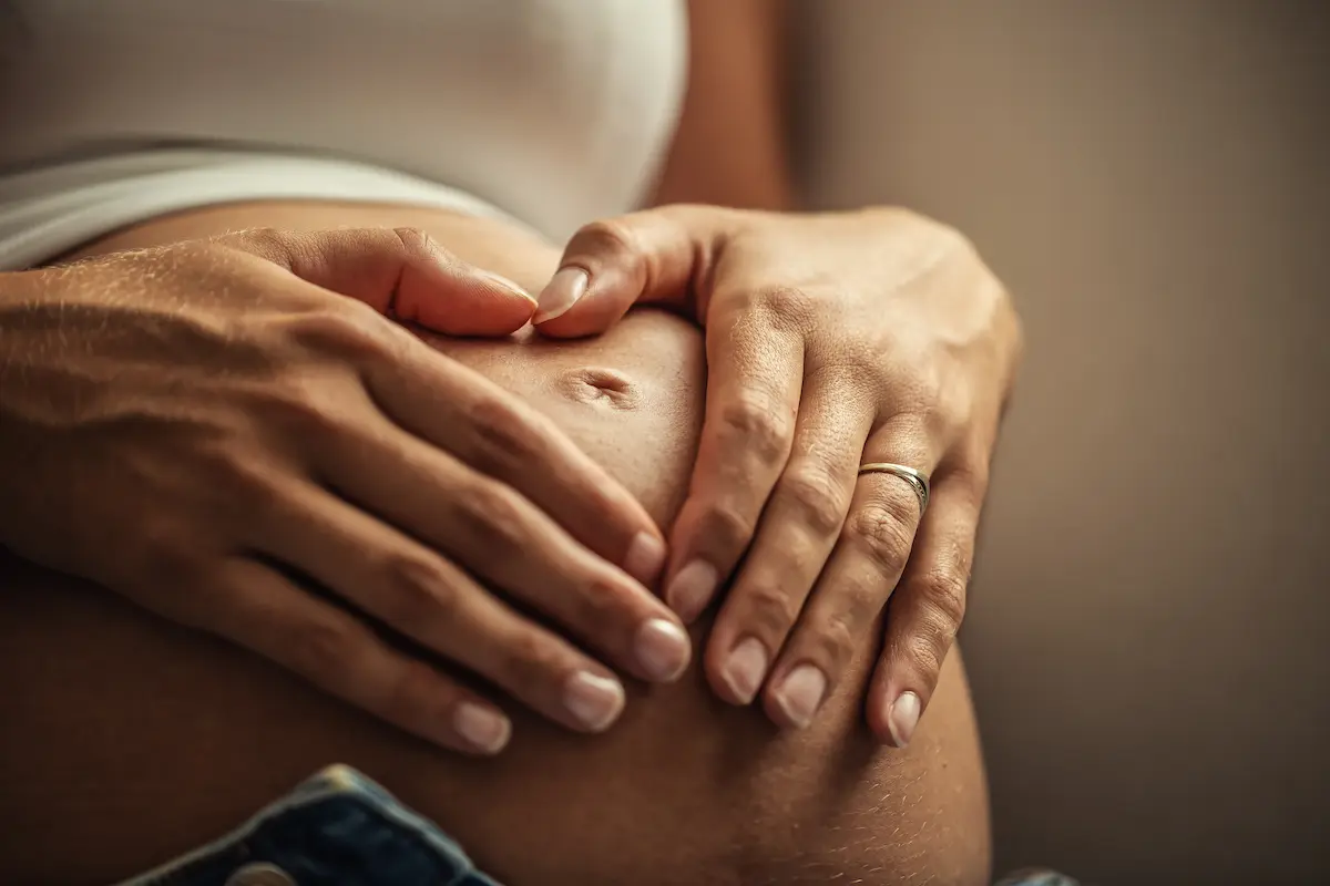 Gestante com as mãos sobre a barriga representa a garantia de estabilidade no emprego durante a gravidez.