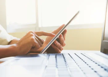 Pessoa utilizando computador para acessar informações sobre concursos públicos.