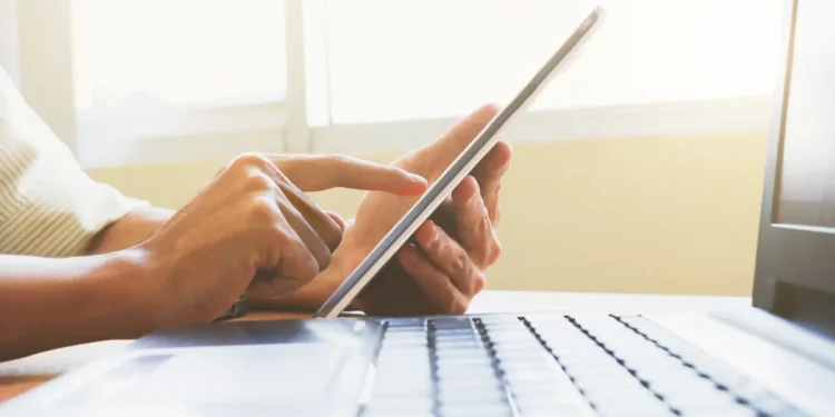 Pessoa utilizando computador para acessar informações sobre concursos públicos.