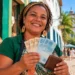 Microempreendedora do turismo segura dinheiro em área histórica representando acesso à linha de crédito para inscritos no CadÚnico