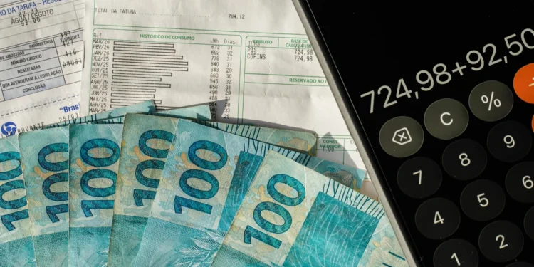 Notas de dinheiro, conta e calculadora representam pagamento da restituição do Imposto de Renda.