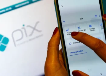 Pessoa acessa o Pix pelo celular em conteúdo sobre prazo de 80 dias para contestação de fraude.