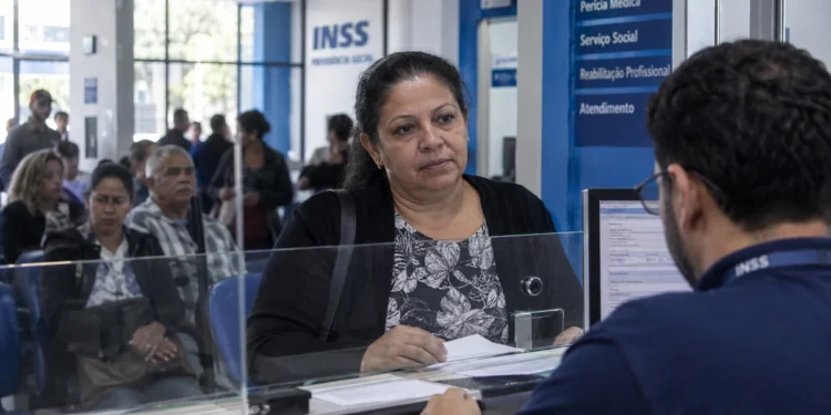 Mulher recebendo atendimento em agência do INSS, representando o mutirão com vagas para perícias médicas e avaliações sociais.