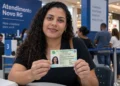 Mulher segura a nova Carteira de Identidade Nacional durante mutirão para emissão do documento em shopping sem agendamento.