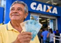 Aposentado segura cédulas em frente à Caixa, representando os pagamentos do INSS de setembro.