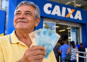 Aposentado segura cédulas em frente à Caixa, representando os pagamentos do INSS de setembro.
