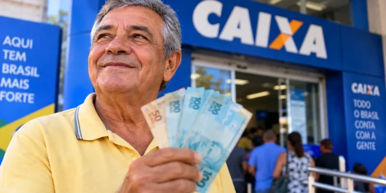 Aposentado segura cédulas em frente à Caixa, representando os pagamentos do INSS de setembro.