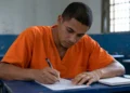 Pessoa privada de liberdade escrevendo, representando o período de inscrições para o Enem PPL 2026.