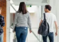 Participantes da Prova Nacional Docente caminham em corredor de instituição de ensino após aplicação das provas.