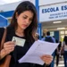 Professora confere documento de identificação e informações, representando o que é necessário para o dia da PND 2026.