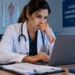 Médica analisa informações em notebook com expressão de preocupação, representando o prazo para apresentação de recursos contra os gabaritos preliminares do Enamed e Revalida.