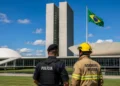 Policial e bombeiro militar em frente ao Congresso Nacional, representando a aprovação do projeto que beneficia essas categorias profissionais.