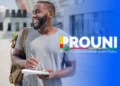 Estudante com material de estudos ao lado do logotipo do Prouni, programa que exige validação de informações pelos pré-selecionados.