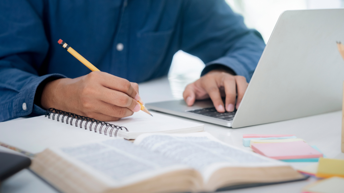 Pessoa estudando para concurso público com notebook e materiais de preparação para o TRT8.