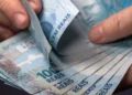 Notas de real sendo contadas representam o pagamento do salário até o quinto dia útil de setembro.