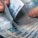 Notas de real sendo contadas representam o pagamento do salário até o quinto dia útil de setembro.