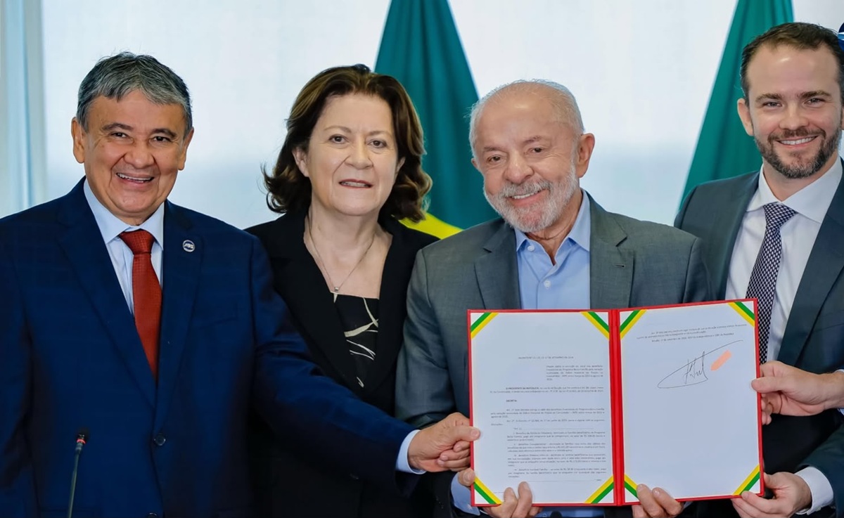 Presidente Lula e ministros exibem o decreto assinado que reajusta os valores do Bolsa Família