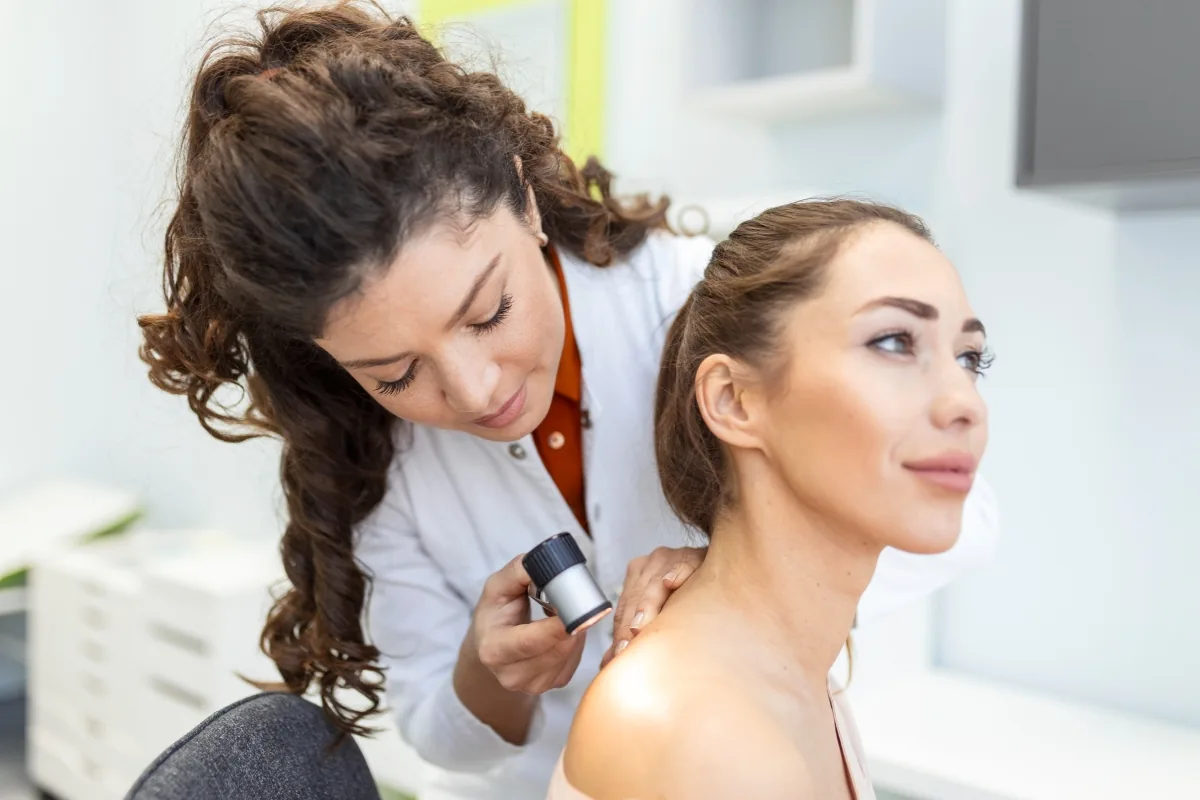 Dermatologista avalia paciente durante consulta, representando a especialidade médica registrada por meio do RQE.