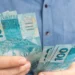 Trabalhador contando cédulas de R$ 100, representando o saque-aniversário do FGTS para nascidos em setembro.